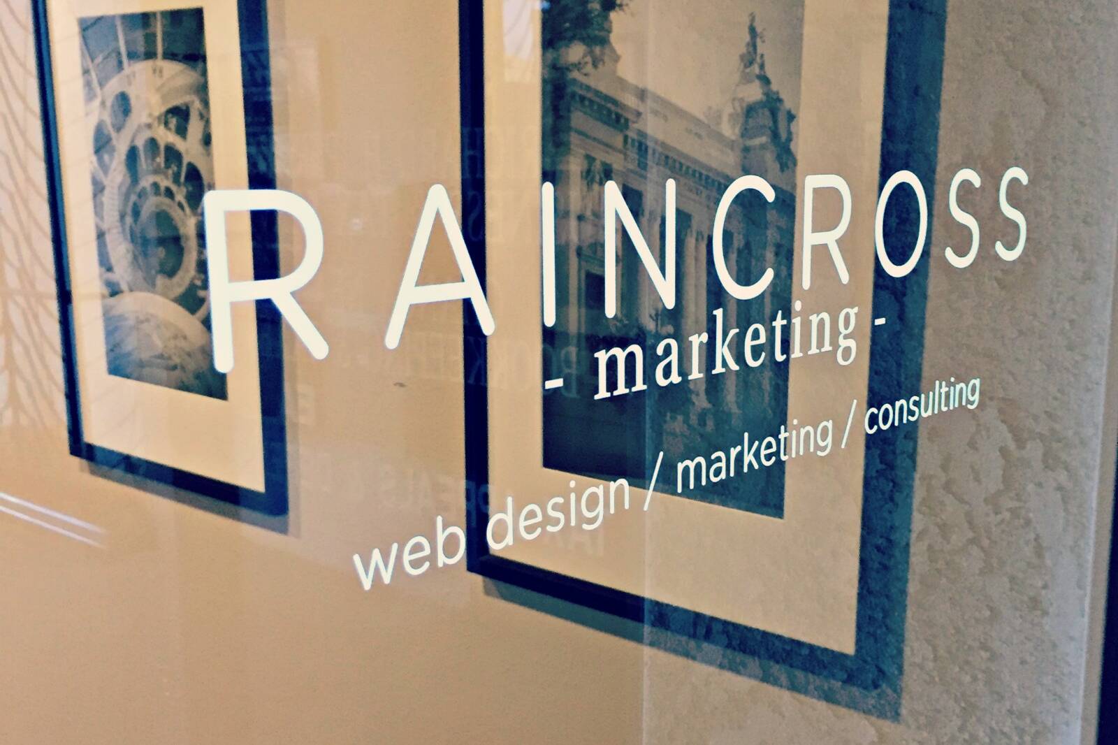 Vinyl lettering on the Raincross office window reading Raincross marketing, web design, marketing, consulting