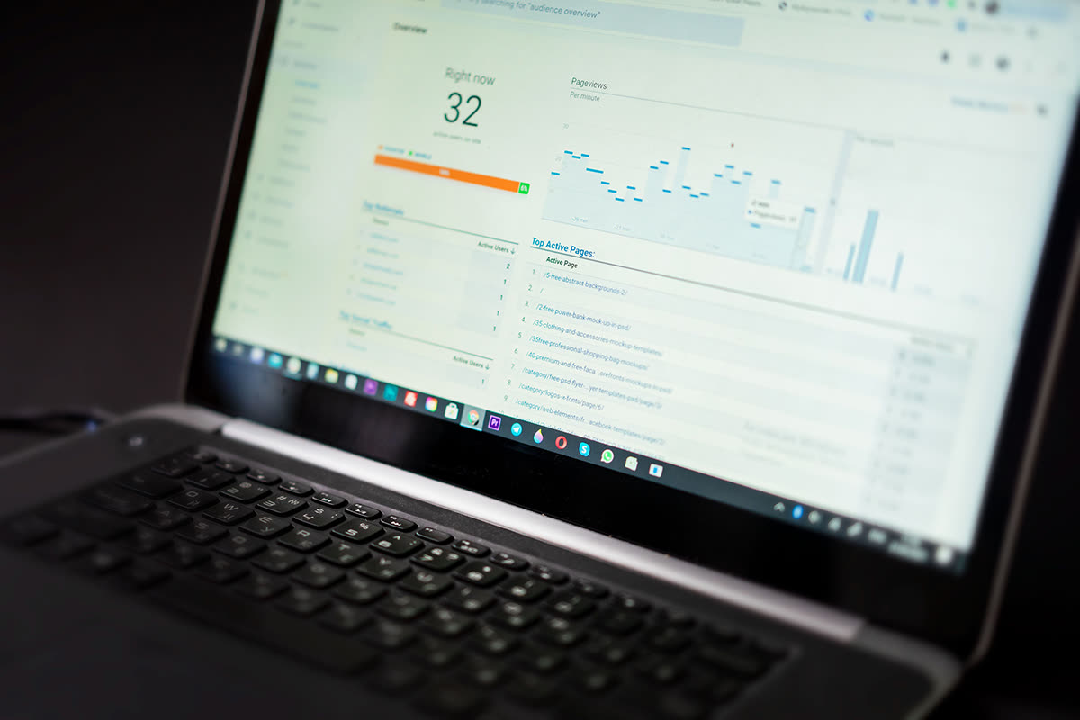 Laptop screen showing a live web analytics dashboard with real-time visitor and pageview reporting