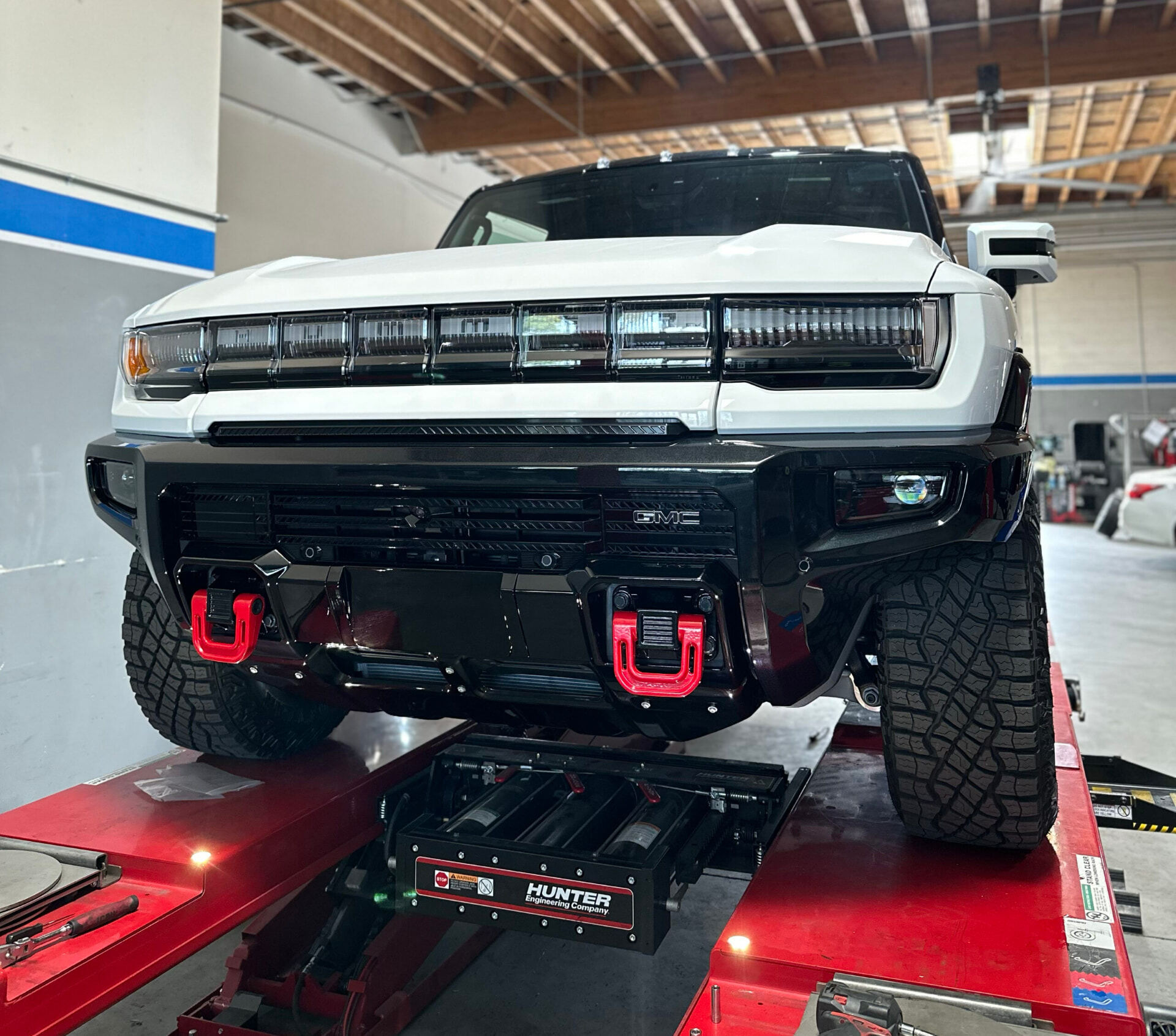 Pickup truck raised on an alignment rack inside a wheel and tire service bay