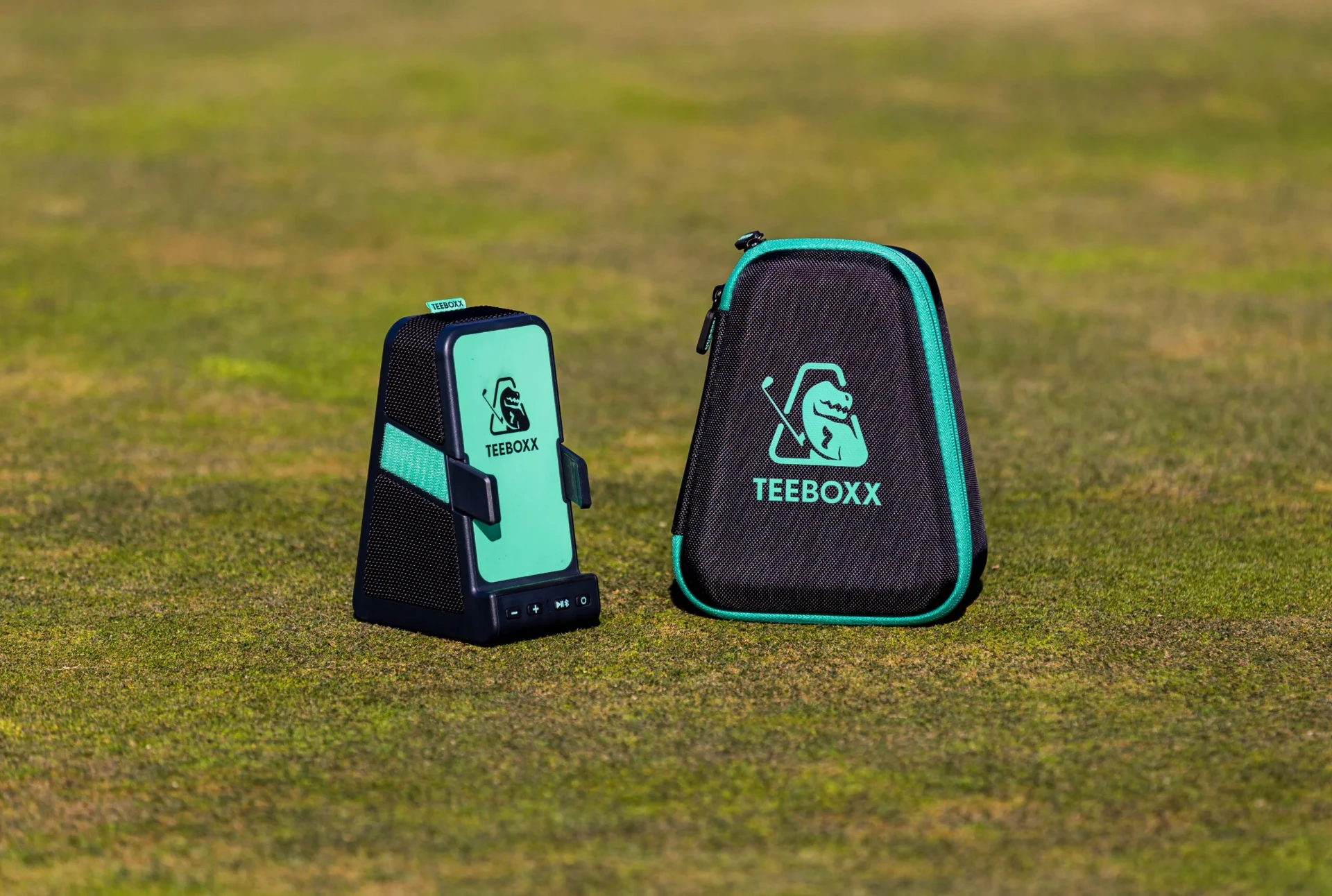 TeeBoxx unit and zippered travel case sitting on a fairway