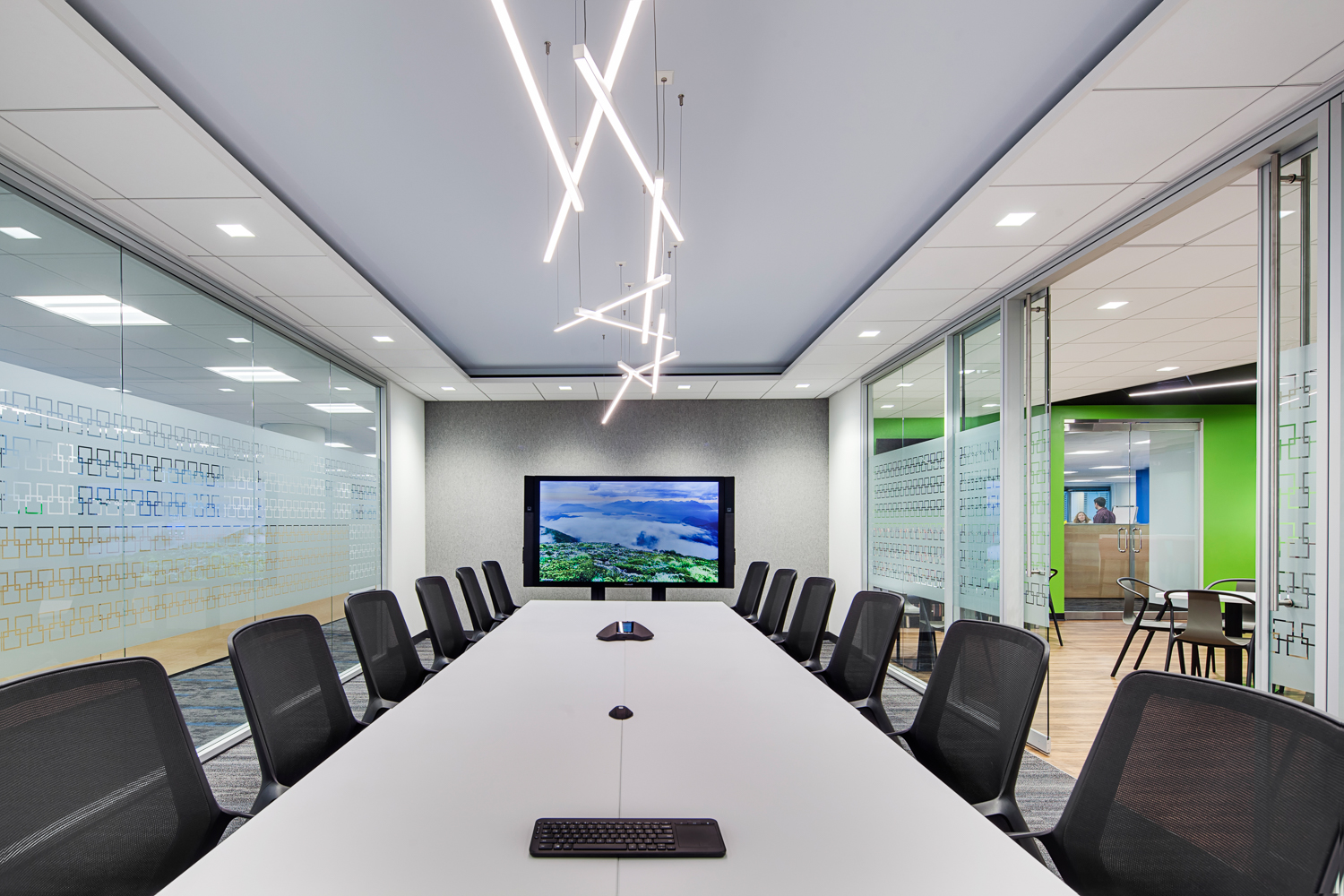 Modern conference room with a long white table and linear light fixtures