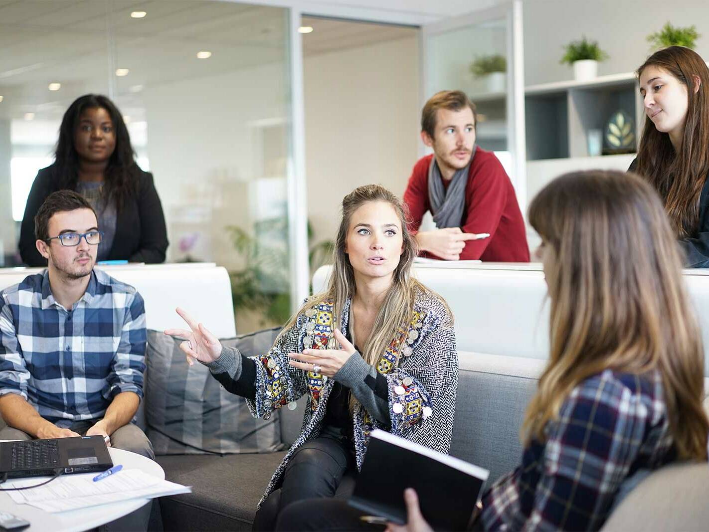 Escrow team discussing a transaction in an open office
