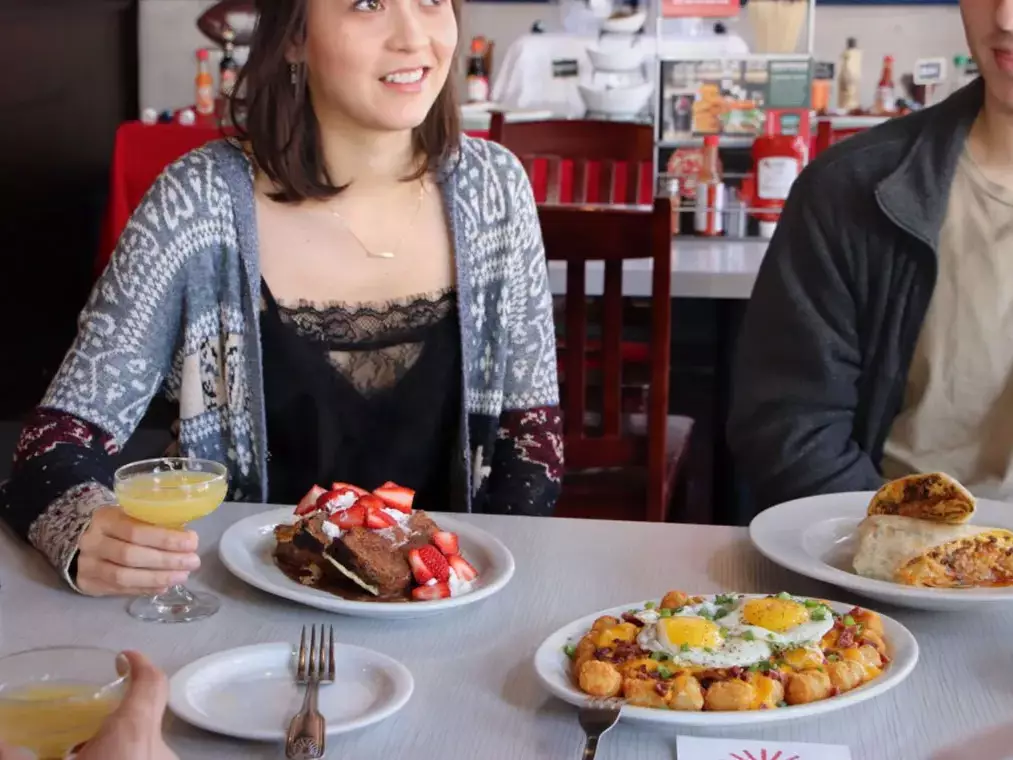 Guests sharing brunch plates and mimosas at a restaurant table