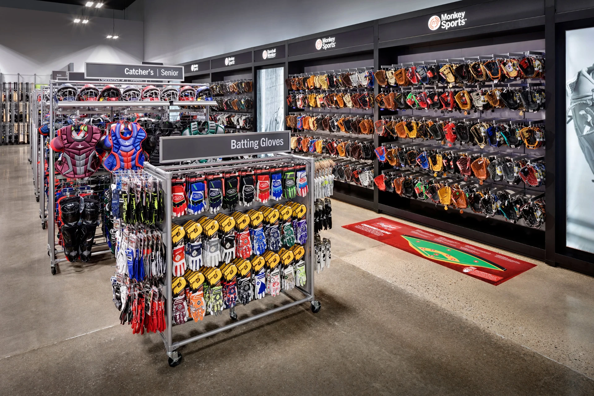 MonkeySports baseball department with batting gloves, catcher's gear, and a wall of mitts