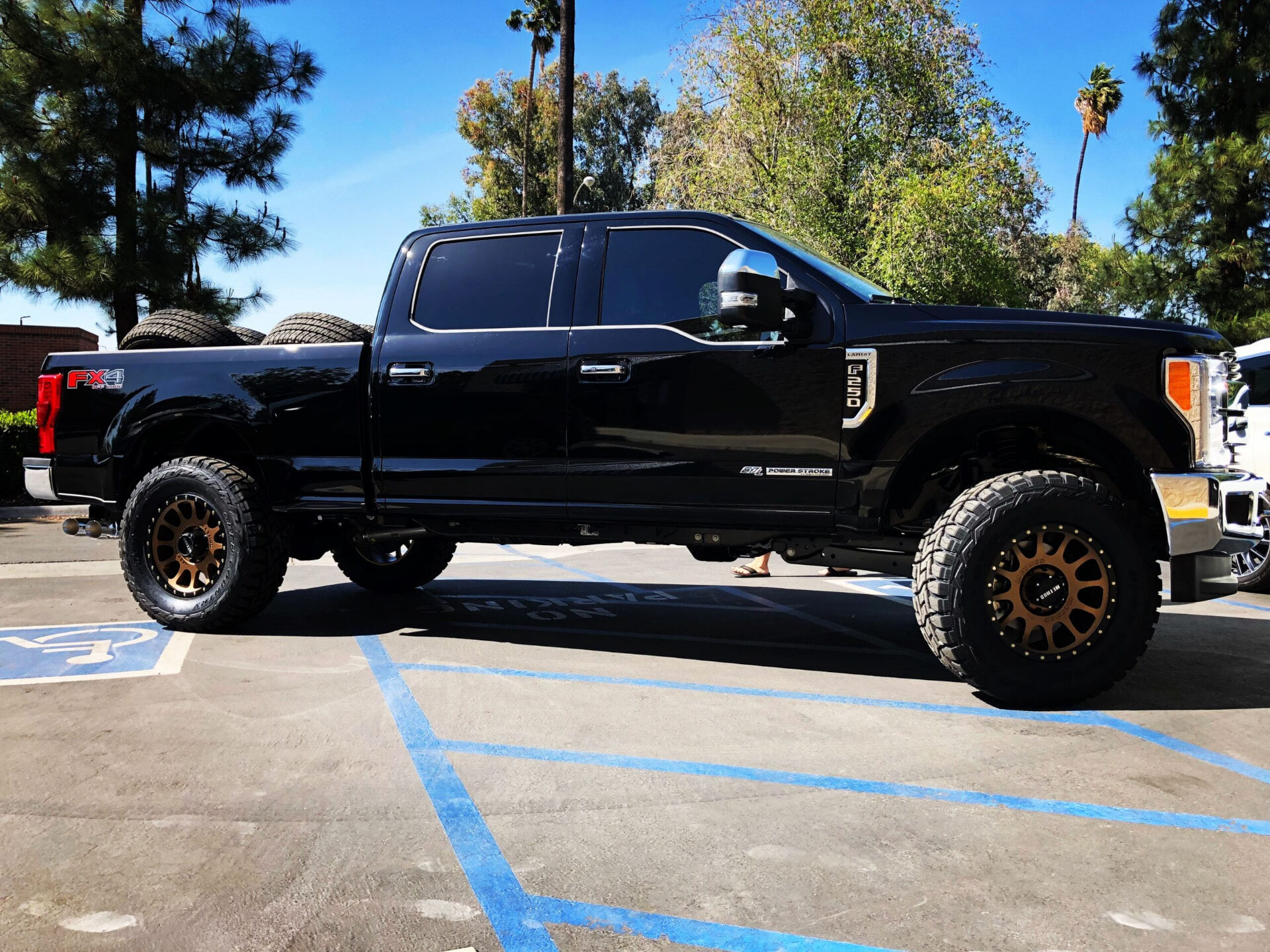 Black heavy duty pickup truck fitted with bronze off-road wheels and all-terrain tires