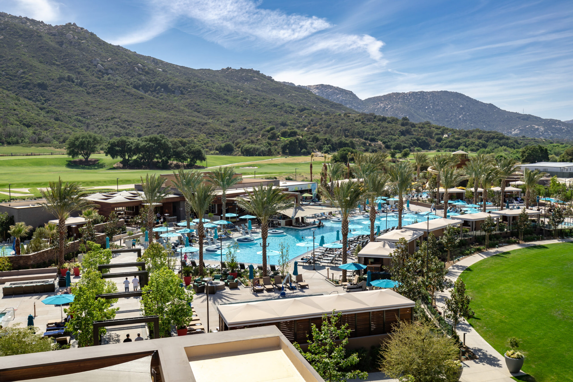 Pechanga resort pool complex with cabanas and palm trees below the hills