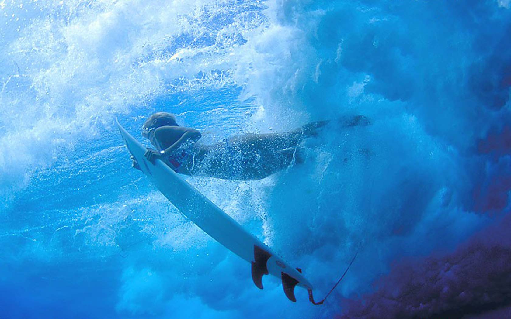 Surfer diving under a breaking wave with a surfboard