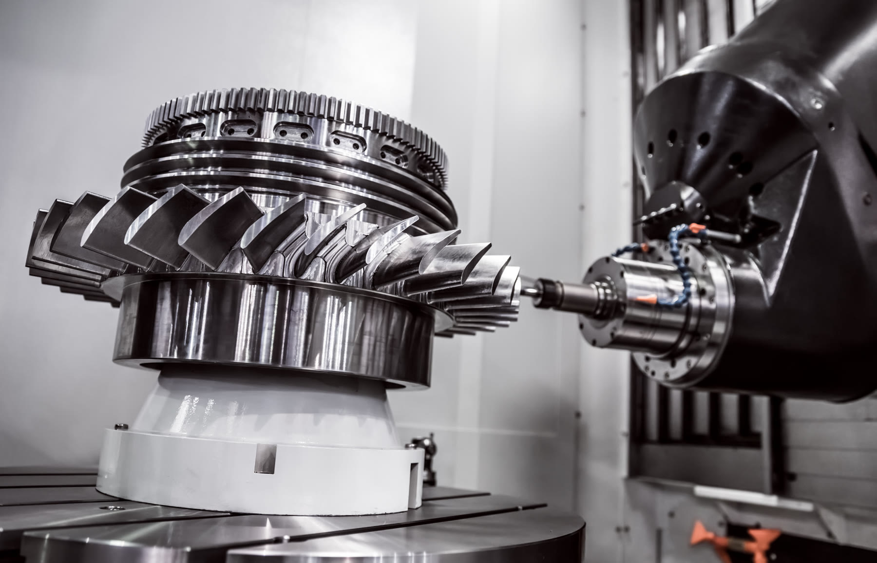 A five-axis CNC machine cutting a precision metal component